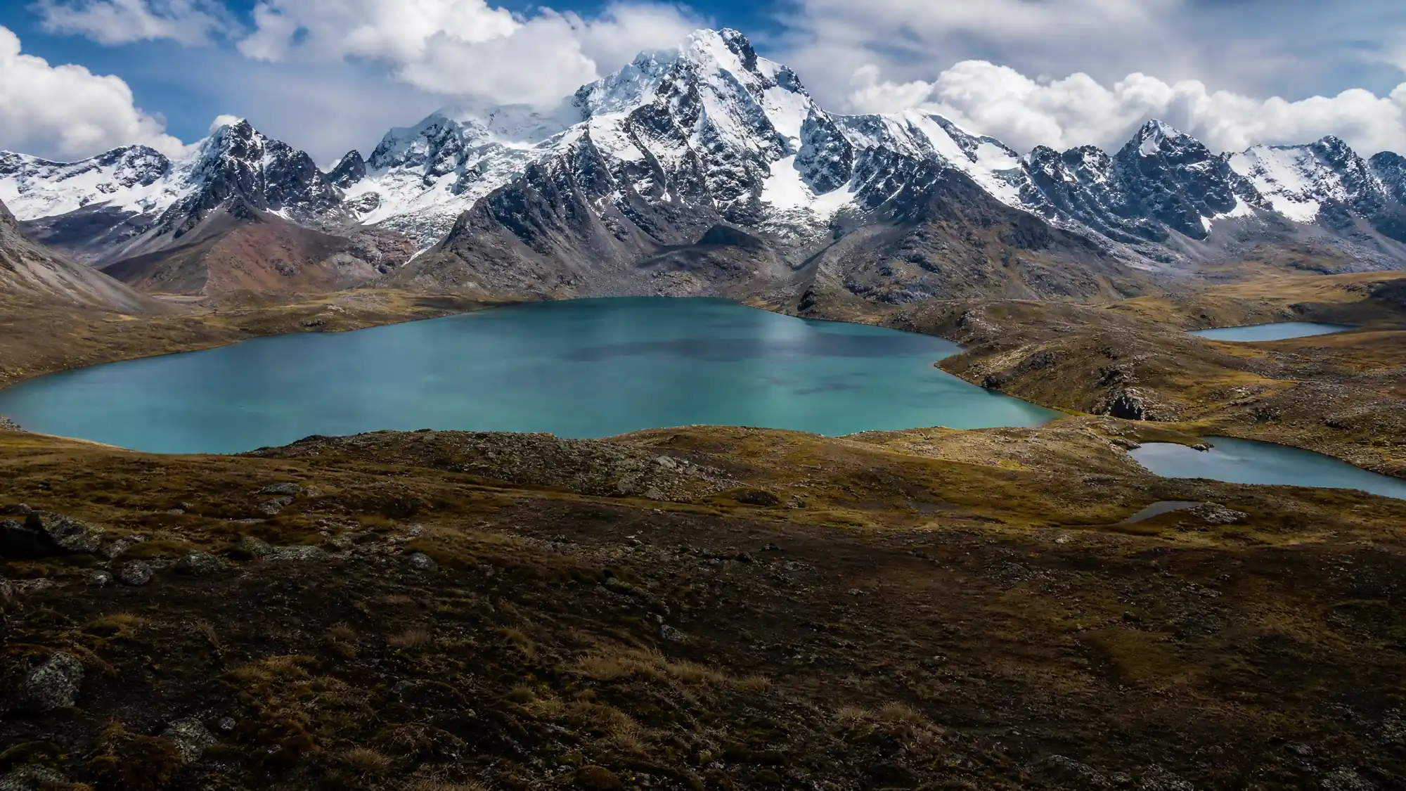 Randonnez le long de sept lacs glaciaires d'altitude au pied de la montagne Ausangate. Ce circuit d'une journée se termine par des bains thermaux naturels à Pacchanta.