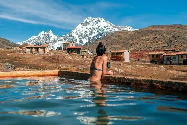 Frau beim Baden in einer Thermalquelle mit dem Ausangate im Hintergrund